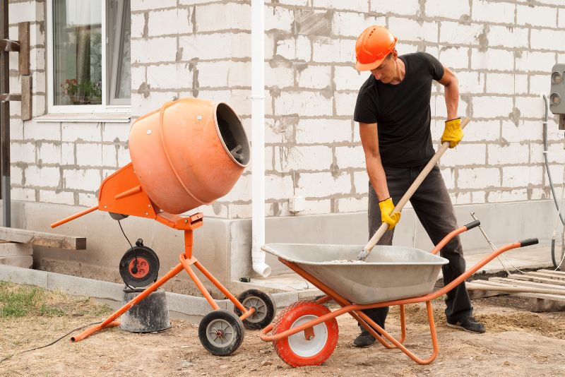 man mixing concrete using a concrete mixer
